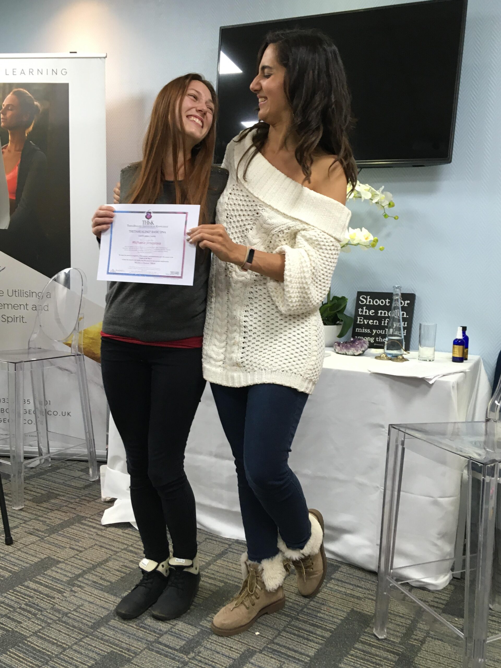 woman holding theta healing practitioner certificate standing next her teacher